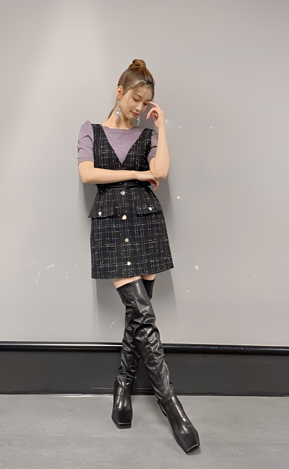 ニーハイブーツを履いた女性が立っている