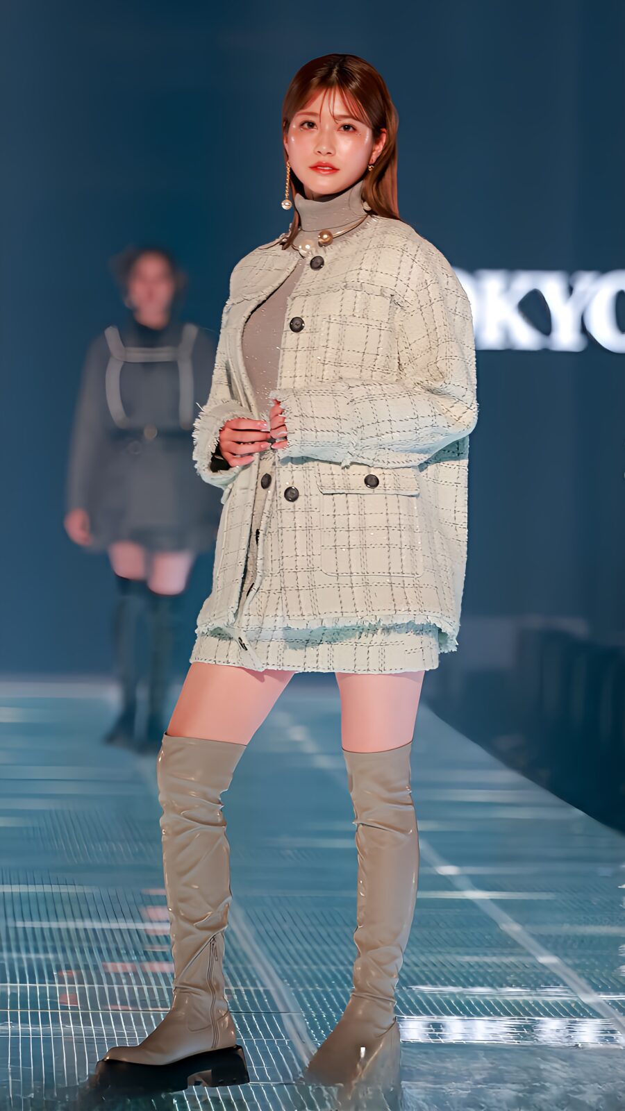 ニーハイブーツを履いた女性が立っている